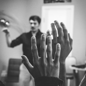 students raising hands in classroom