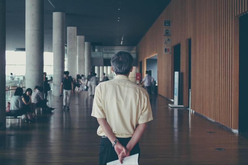 portrait of person holding papers behind back
